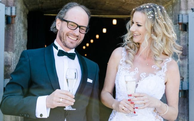 Hochzeitsfotografie Nörten Hardenberg lächelnd mit Sektgläsern
